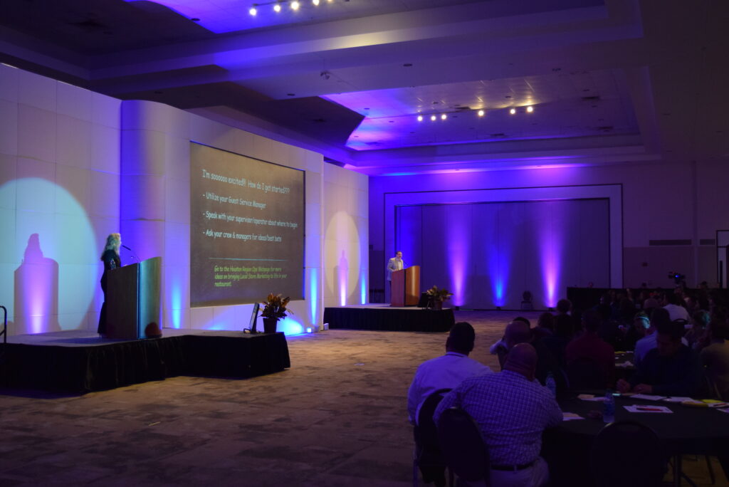 Video screens and stage lights at a meeting